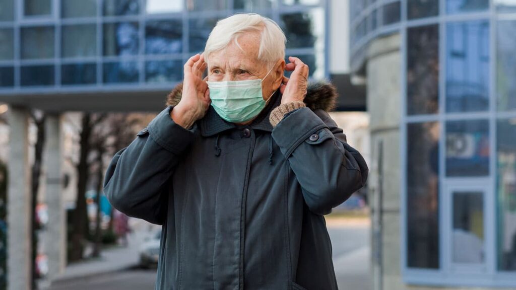 anciano con mascarilla cuidándose del COVID-19